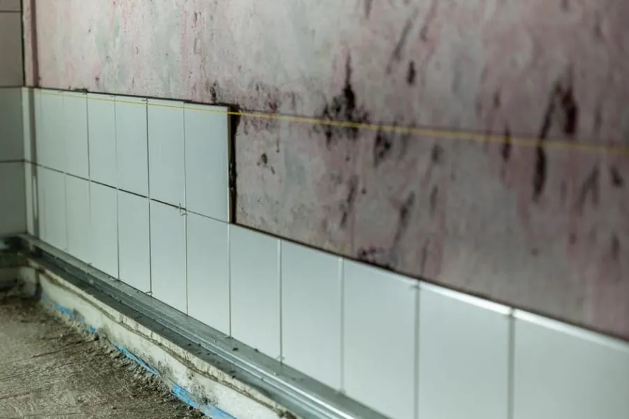 Partially tiled wall in a bathroom under construction
