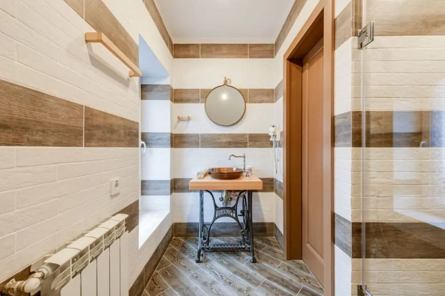White bathroom radiator on a tiled wall