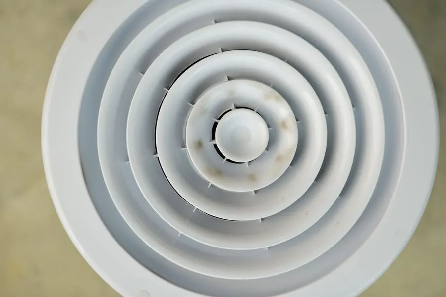 White concentric circular vent or speaker grille with a small central hub, viewed from above