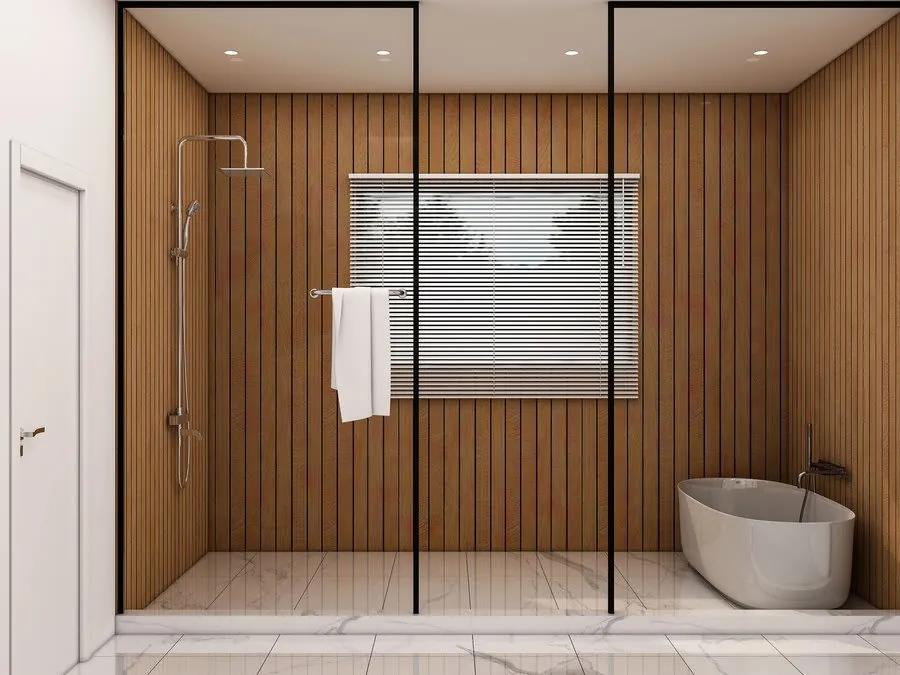 Modern bathroom with wood-paneled wall, glass shower, towel, window blinds, and freestanding tub