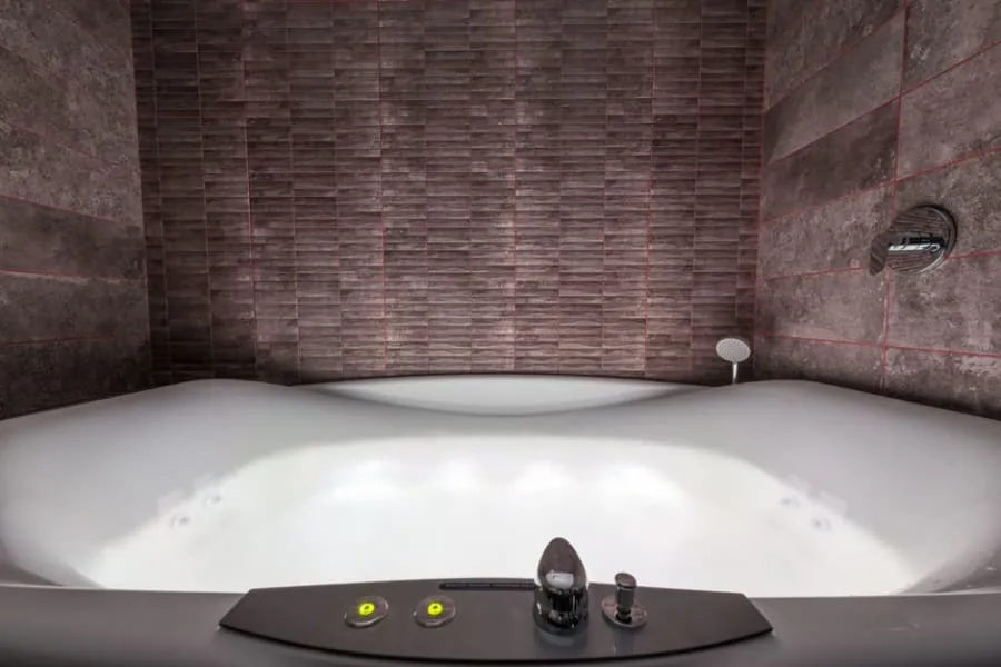 Built-in bath with a panel in a tiled Derby bathroom