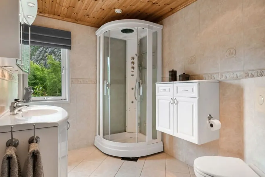 Small cloakroom with a glass-screened WC and an extractor for ventilation
