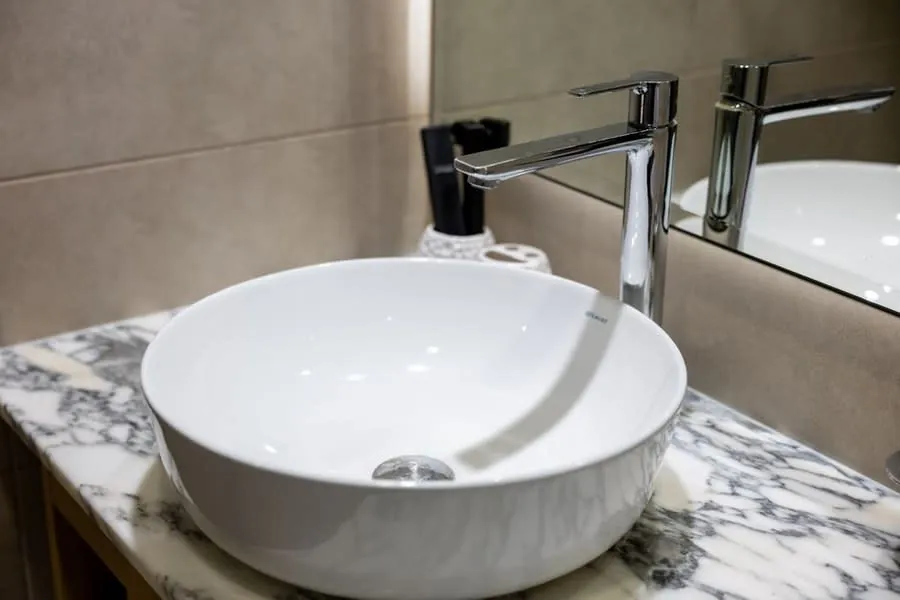 Countertop basin on a marble-topped vanity unit