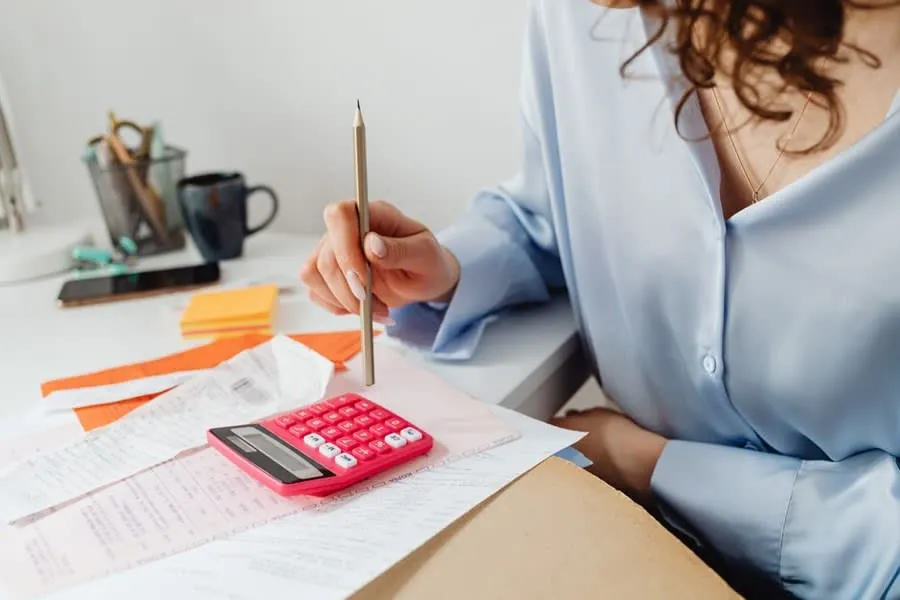 Working out bathroom renovation costs, VAT and staged payments at a desk