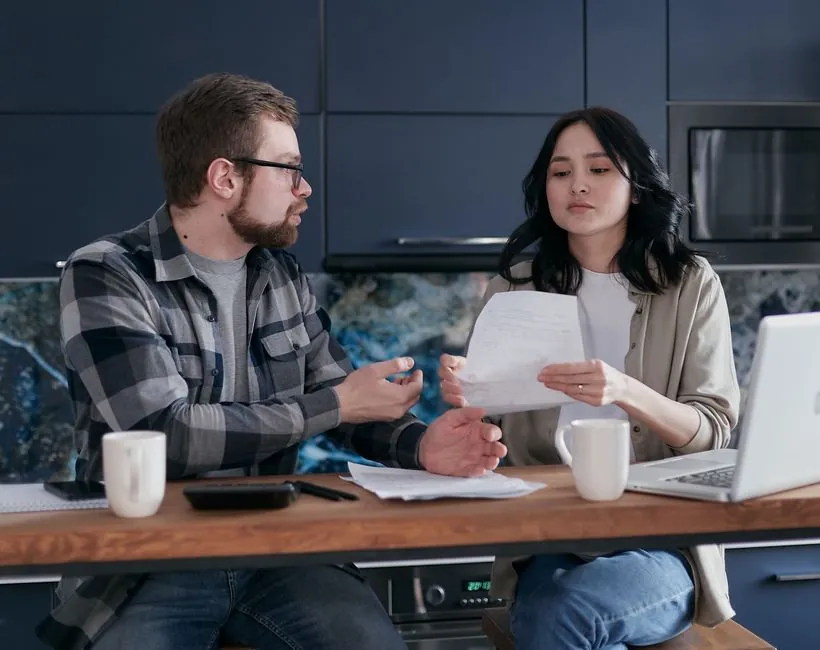 Comparing bathroom renovation quotes and finance offers at a kitchen table in Derby