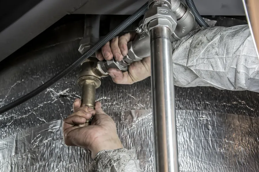 Plumber fitting a shower valve during a guaranteed bathroom installation in Derby