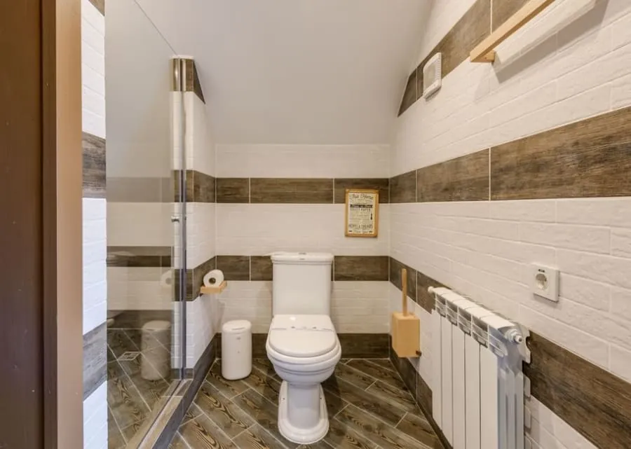 Compact downstairs toilet fitted into a small white-tiled space