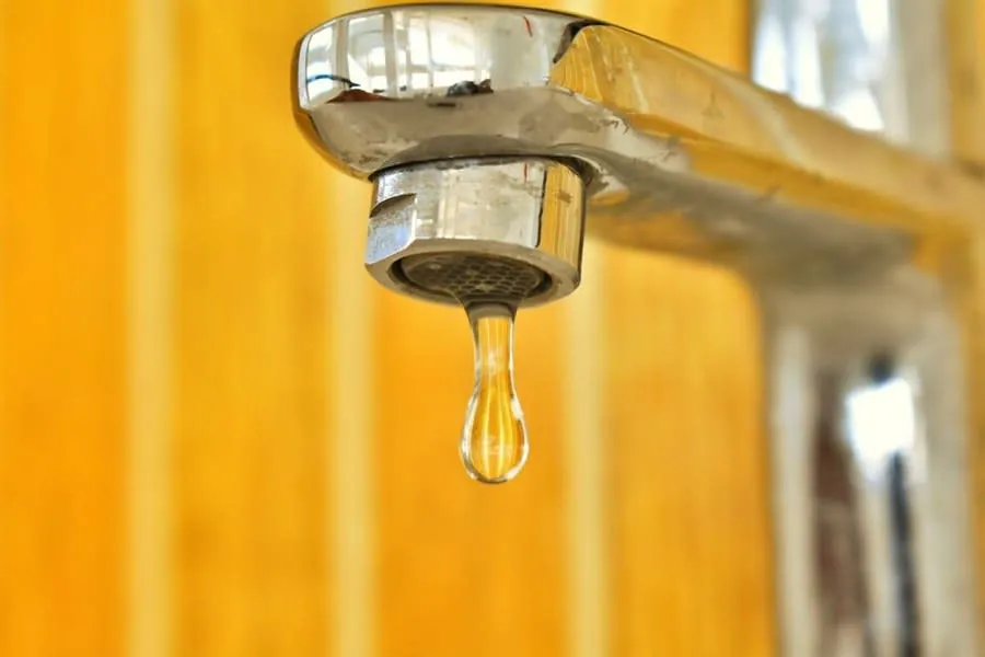 Water droplet on a chrome fitting showing hard water mineral content