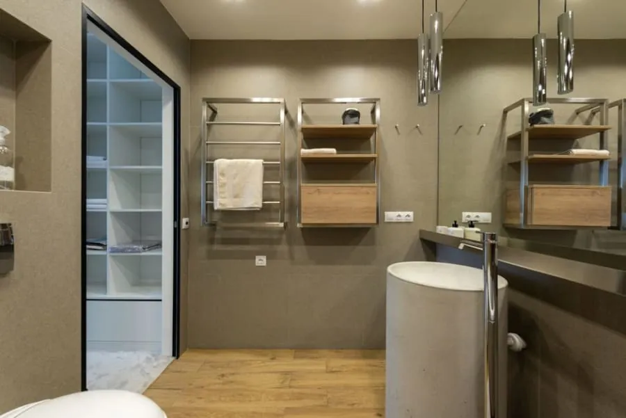 Modern bathroom with a shower, washing machine, sink vanity, and towel rack