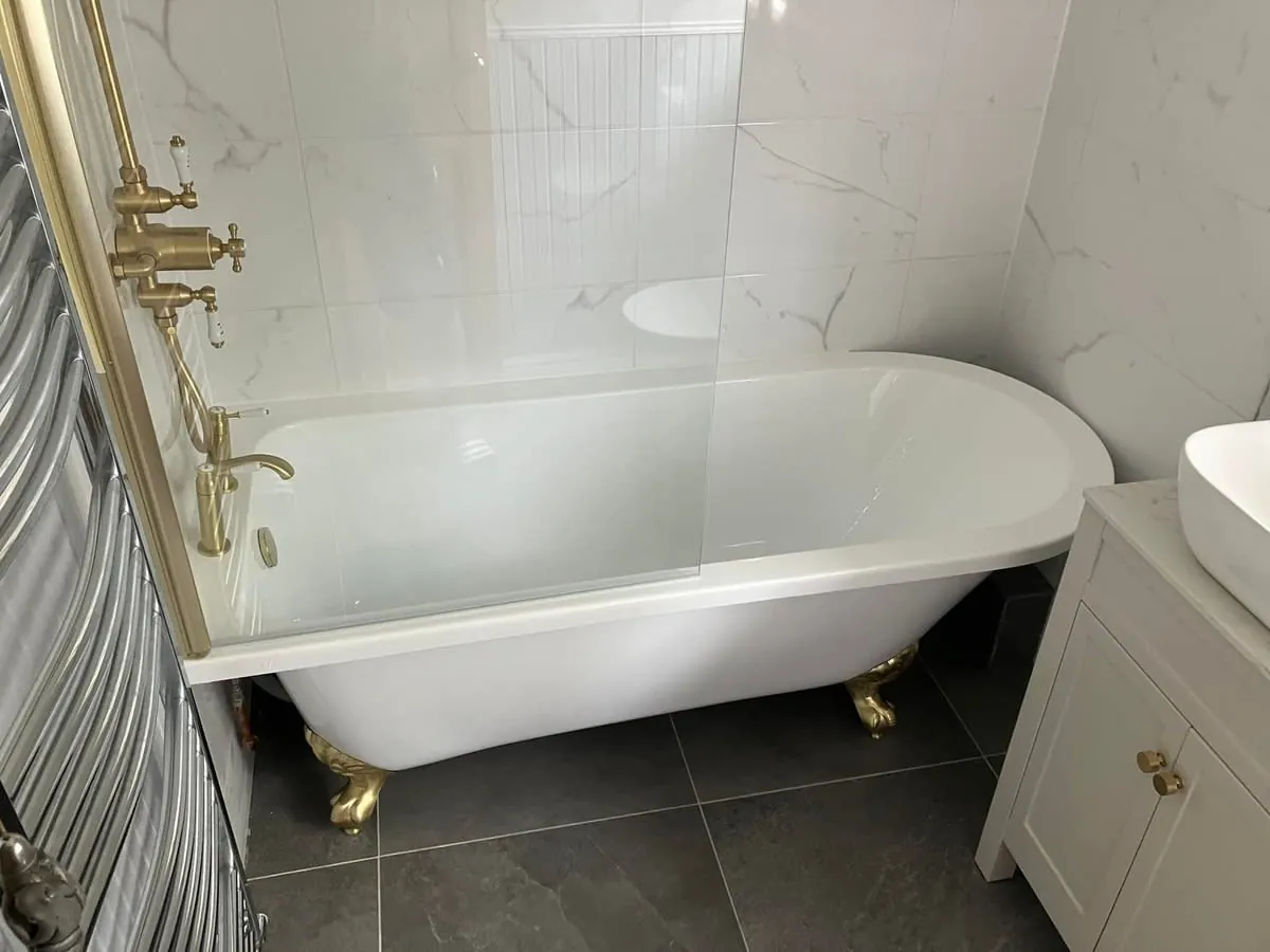 Freestanding claw-foot bath in a Derby bathroom with marble tiling